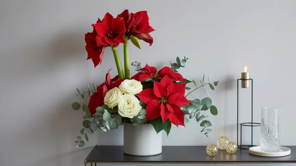 Christmas floral arrangement with red poinsettias, white roses, and pine greenery in vase.