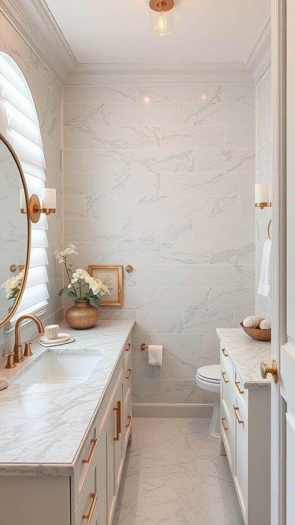 A stylish bathroom featuring a marble countertop, white cabinetry, and gold fixtures.